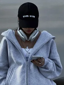 Detail of gray zip-up hoodie with oversized fit and high-quality fabric texture.