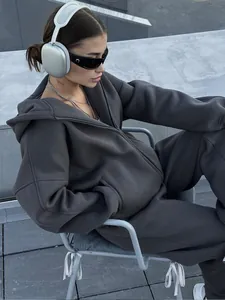 Lifestyle shot showing the fit and texture of a charcoal grey oversized zip-up hoodie set