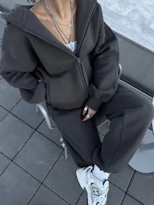 Detailed view of dark grey oversized zip-up hoodie and matching joggers on model