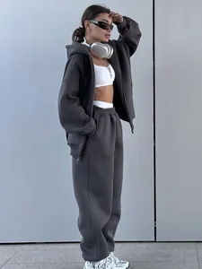 Side view detail of loose-fit dark grey tracksuit on model in urban setting