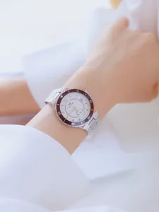 Primer plano de un reloj de acero inoxidable para mujer con esfera blanca y bisel