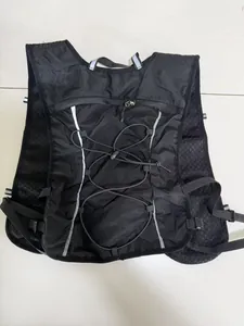 Back view of a black running hydration vest with reflective strips and bungee cords