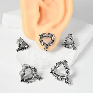 Vista detallada de dilatadores de oreja de acero con forma de corazón y calaveras