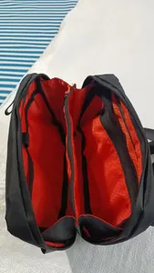 Detalle del forro naranja en forma de panal y los compartimentos internos de la riñonera negra