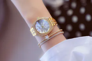Primer plano de un reloj de cuarzo dorado de lujo con diamantes y pulsera de estrella