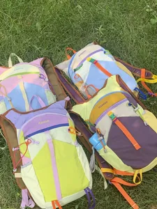 Colorful dopamine-style outdoor hiking backpacks for women displayed on green grass scene