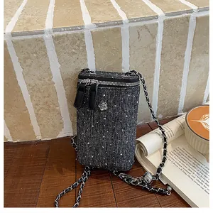 Close-up view of the French style tweed crossbody phone bag with a stylish camellia ornament