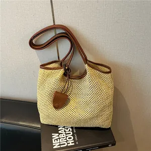 Dettaglio ravvicinato di una borsa tote in paglia con manici in pelle marrone