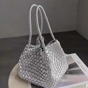 Silver woven bucket handbag with exquisite craftsmanship on a minimalist grey background