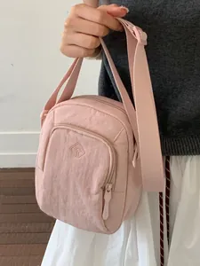 Kompakte pinkfarbene Nylon-Umhängetasche mit verstellbarem Riemen und Reißverschlusstasche