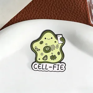 Detailed macro shot of a cartoon cell-fie biology themed green enamel pin brooch
