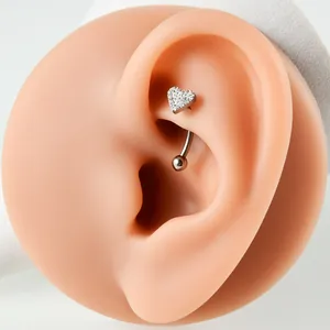 Close-up of G23 titanium curved barbell piercing with sparkling zircon heart on ear model