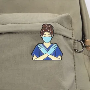 Détail rapproché d'un pin's en émail infirmière de dessin animé sur un sac à dos en toile kaki