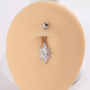 Primer plano de un piercing para el ombligo de acero inoxidable con flor de circón
