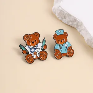 Detail view of cartoon teddy bear doctor and nurse enamel pins on a beige surface