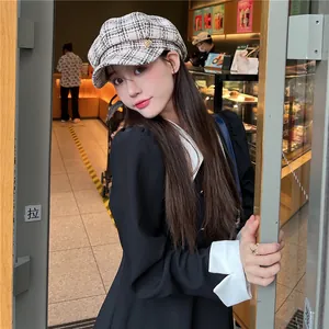 Elegant black and white plaid newsboy hat for women styled in a modern cafe setting