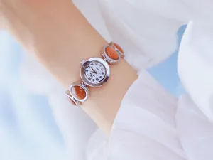 Primer plano del elegante reloj Bee Sister para mujer con pulsera de piedra de arena.