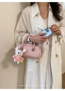 Vue détaillée du sac à main de bowling rose avec charm en peluche mignon et chic.