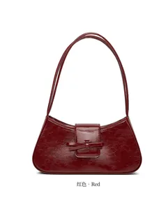 Detaillierte Ansicht einer stilvollen dunkelroten glänzenden Tasche mit Zierschleife.