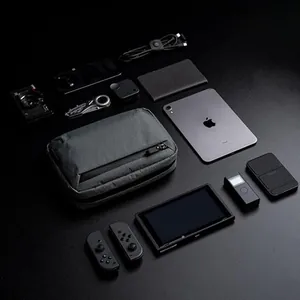 Bolso bandolera táctico gris EDC con iPad y gadgets para mostrar la capacidad de carga