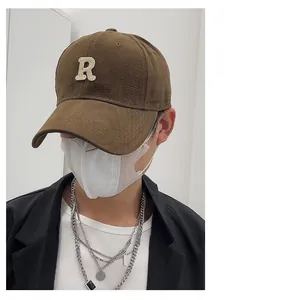Close-up of a brown brushed baseball cap featuring an 'R' logo patch on a male model.