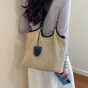 Dettaglio di una grande borsa tote in paglia intrecciata per vacanze e uso quotidiano
