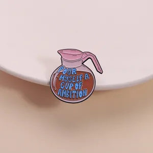 Detailed close-up of a pink coffee pot enamel pin with blue inspirational slogan text