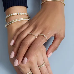 Elegant S925 sterling silver zirconia rings and gold bracelets set worn on hands with pink nails