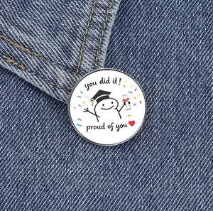 Detail macro view of a cute graduation cartoon character metal pin badge on blue denim fabric