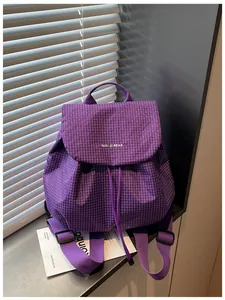 Close-up detail of a purple checkered small backpack for casual women's daily commute