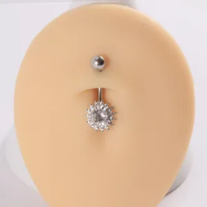 Detalle del piercing de ombligo con circonita en forma de flor en acero inoxidable