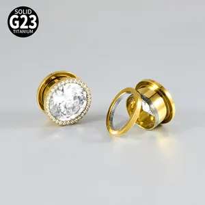 Detail view of G23 titanium ear gauges with gold plating and zircon inlay