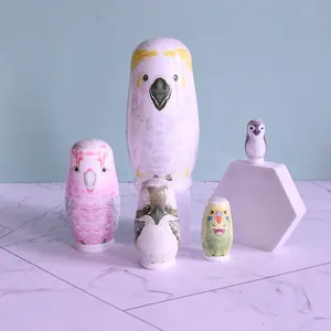 Close-up detail of a 5-piece wooden bird nesting doll set on a marble surface decor.
