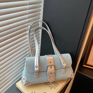 Light blue denim baguette bag with silver buckles and stud detailing