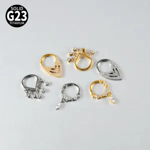 Macro view of G23 titanium piercing rings with zircon tassels in gold and silver finish.