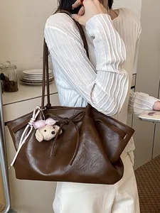 Bruine kunstleren grote tote tas met strikdetail en een schattige pluizige hondenbedel