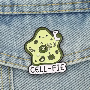 Close-up of a funny biological cell 'CELL-FIE' enamel pin on a denim jacket pocket.