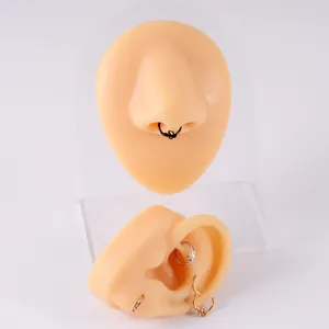 Snake shaped stainless steel septum nose ring and earring set shown on display models.