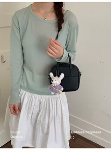Schicke kleine quadratische Handtasche aus schwarzem genarbtem Leder mit Hasenanhänger
