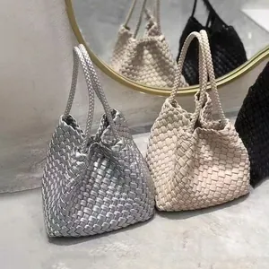 Close-up of premium handmade woven bucket bags in silver, beige, and black finishes.