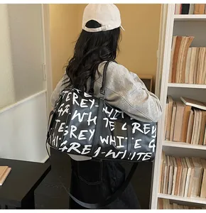 Large capacity black travel duffle bag with white graffiti letters for women gym and trip.
