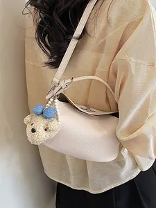 Elegant beige bucket bag with cute plush bear charm for versatile daily use