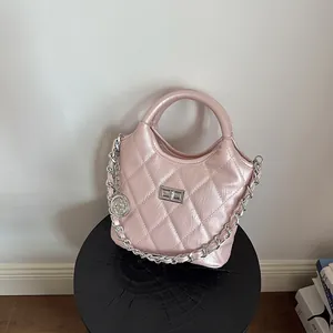 Close-up of pink metallic quilted handbag with silver chain and twist lock detail