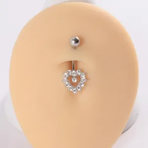 Detalle de un piercing para el ombligo con forma de corazón en acero y circonitas