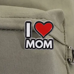 Primer plano detallado del pin esmaltado I Love Mom con corazón rojo en mochila verde