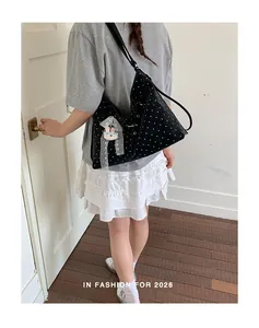 Detailed view of large black polka dot tote bag with cute rabbit charm and ribbon