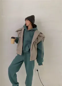 Modelo asiática luciendo un conjunto de tres piezas de sudadera con capucha y pantalón
