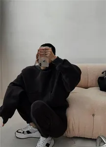 Modelo con sudadera con capucha y pantalones deportivos negros de felpa de gran tamaño