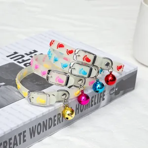 Close-up of fluorescent silicone pet collars with colorful bells and footprint patterns