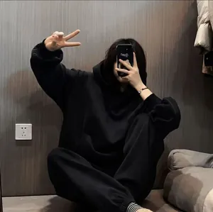Cómodo conjunto de sudadera y pantalón jogger de felpa negra en un entorno de estilo de vida